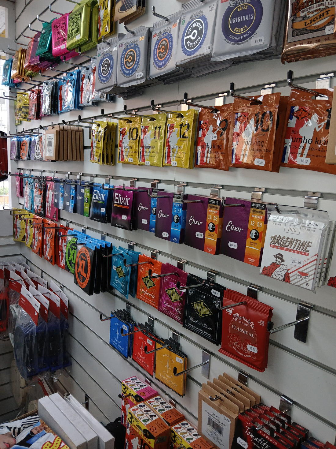Selection of guitar strings showing different gauges and materials for acoustic and electric guitars