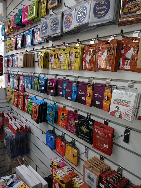 Selection of guitar strings showing different gauges and materials for acoustic and electric guitars